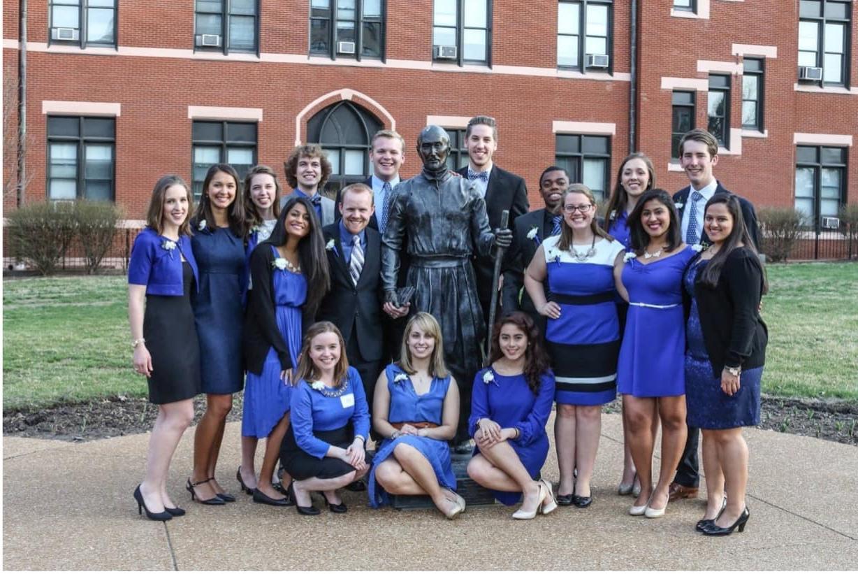 A group of students pose for a photo together outside on campus.