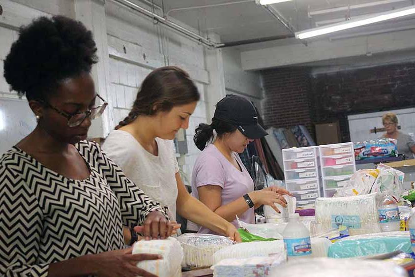 Students in work on a service project standing in a line at a counter